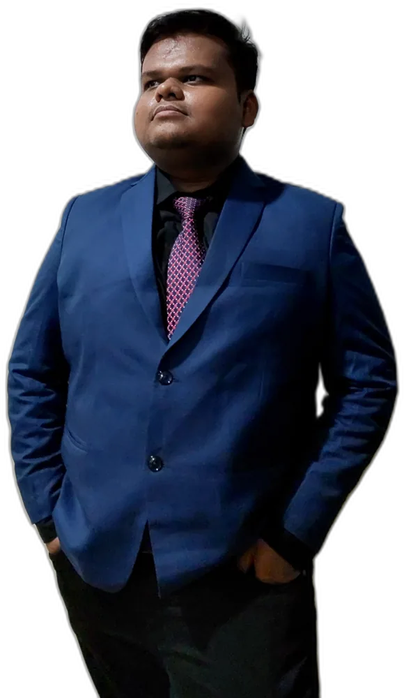 Aditya in a blue suit, hands in pockets, looking off to the side